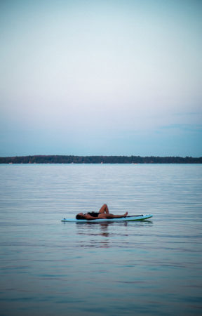Girl laying down on SUP in Lake Simcoe | Vikash Autar Television Program Film Director Hong Kong and Sydney